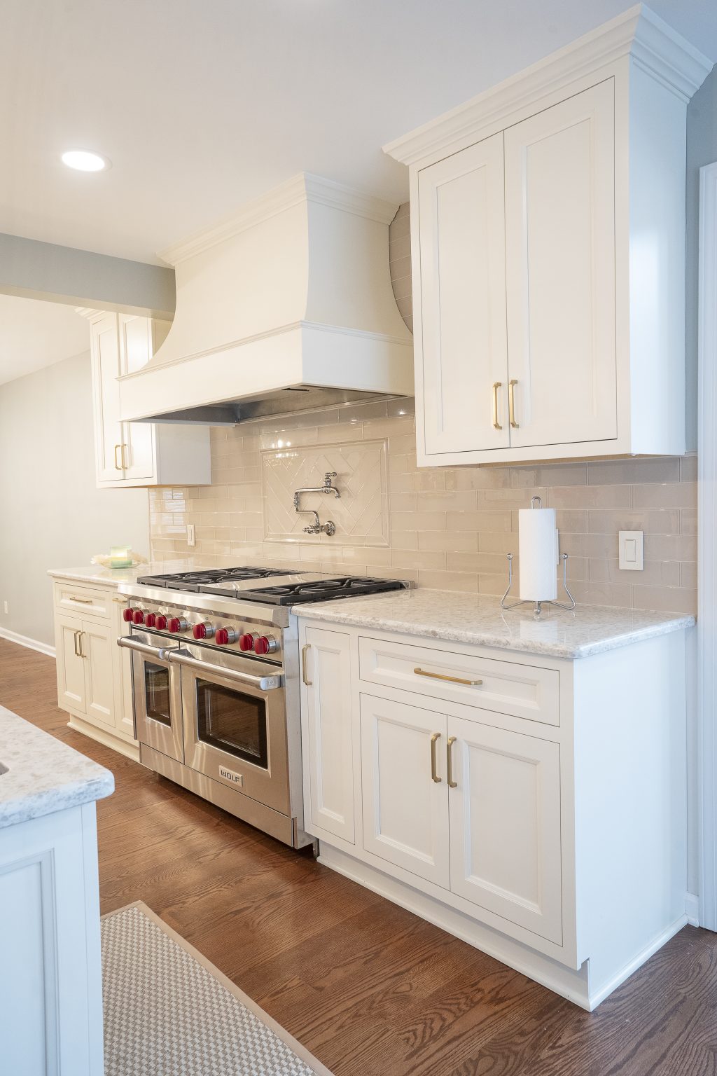 Professional-grade stainless steel range with stylish hood built into white cabinetry by a kitchen remodeler in Ottawa Hills.