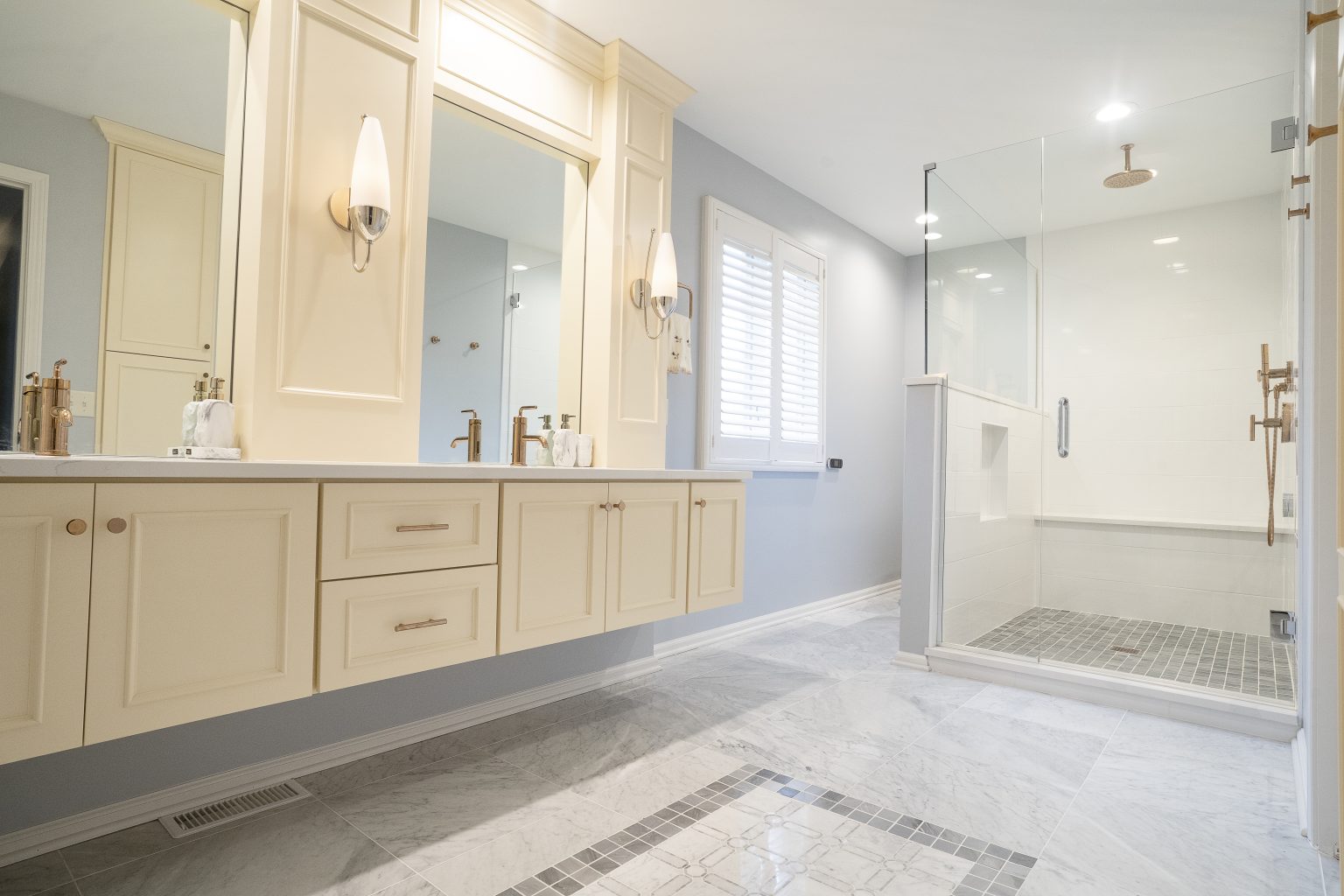 Light colored dual vanity and spacious walk-in shower installed by bathroom remodeler in Ottawa Hills